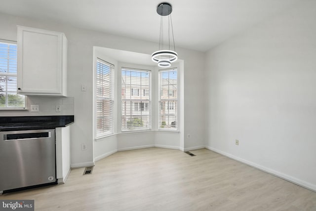 21748 Kings Crossing Ter, Ashburn, VA 20147 - unfurnished dining area with light wood-style flooring, healthy amount of natural light, and a chandelier
