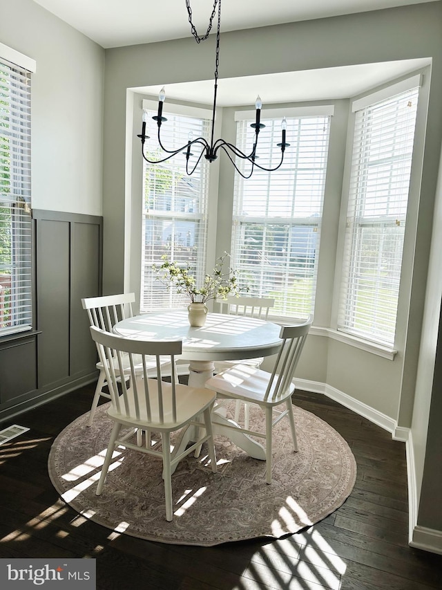 8168 Poinsett Ter, Pasadena, MD 21122 - dining room featuring a chandelier, dark wood-style floors, healthy amount of natural light, and baseboards
