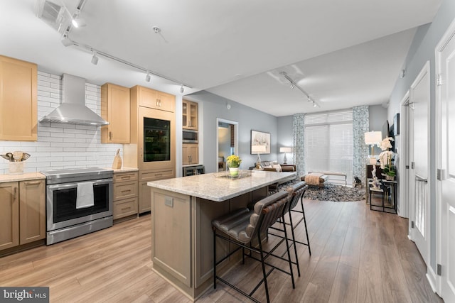 155 Potomac Unit 413, National Harbor, MD 20745 - kitchen featuring rail lighting, appliances with stainless steel finishes, wall chimney exhaust hood, and light wood-type flooring