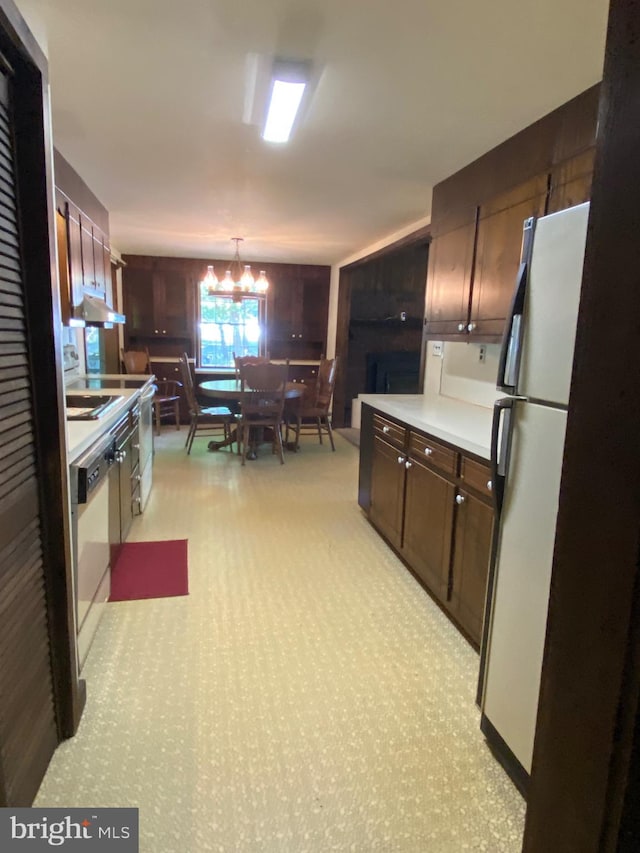 724 Ocean Ave, Galloway, NJ 08205 - kitchen with freestanding refrigerator, a chandelier, light countertops, dark brown cabinets, and dishwashing machine