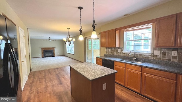 9 Whirlaway Dr, Bear, DE 19701 - kitchen with a sink, black appliances, a kitchen island, wood finished floors, and decorative backsplash