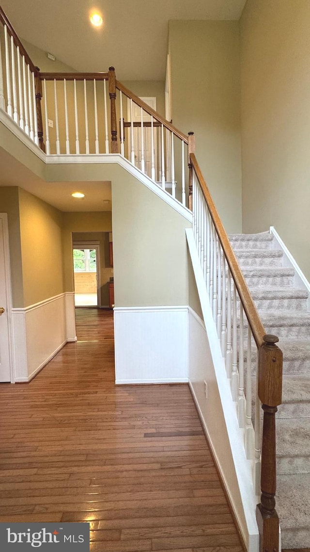 9 Whirlaway Dr, Bear, DE 19701 - staircase with a wainscoted wall, wood finished floors, a towering ceiling, and recessed lighting