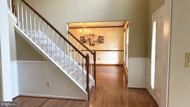 9 Whirlaway Dr, Bear, DE 19701 - stairs with a chandelier, wood-type flooring, and wainscoting