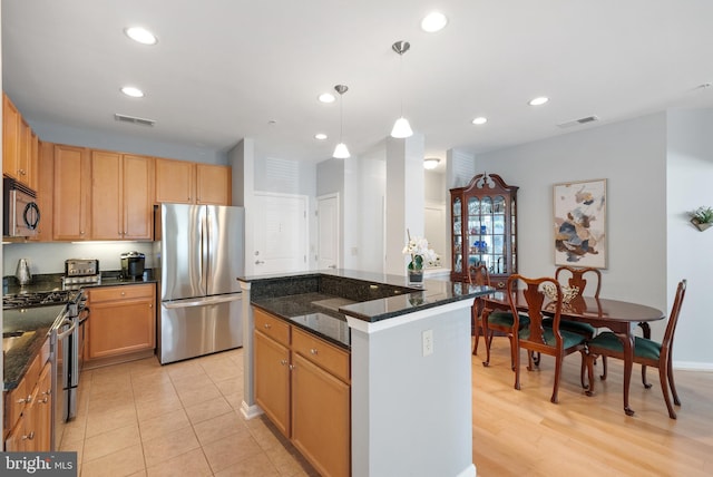 2665 Prosperity Ave Unit 109, Fairfax, VA 22031 - kitchen with stainless steel appliances, recessed lighting, hanging light fixtures, a center island, and dark stone counters