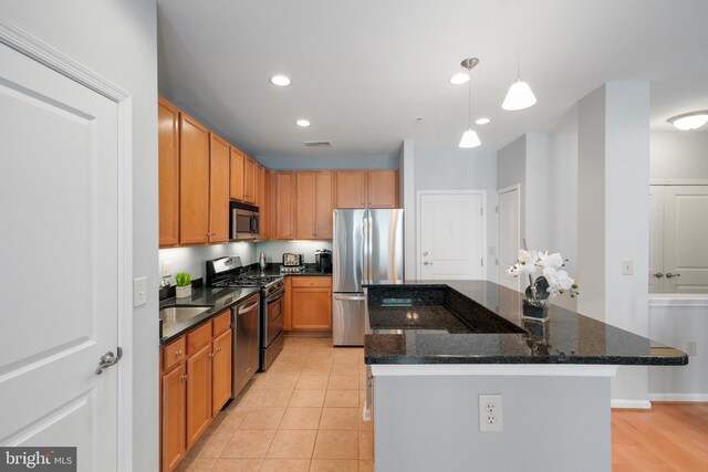 2665 Prosperity Ave Unit 109, Fairfax, VA 22031 - kitchen featuring stainless steel appliances, a kitchen island, hanging light fixtures, dark stone countertops, and recessed lighting