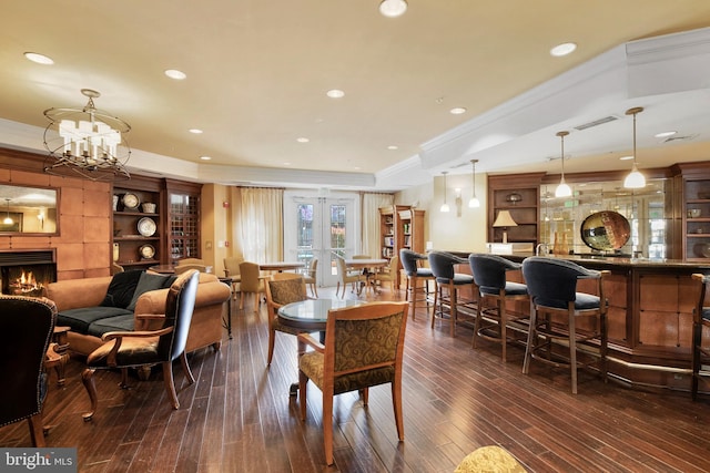 2665 Prosperity Ave Unit 109, Fairfax, VA 22031 - dining area with ornamental molding, a raised ceiling, dark wood-style flooring, a chandelier, and a community bar