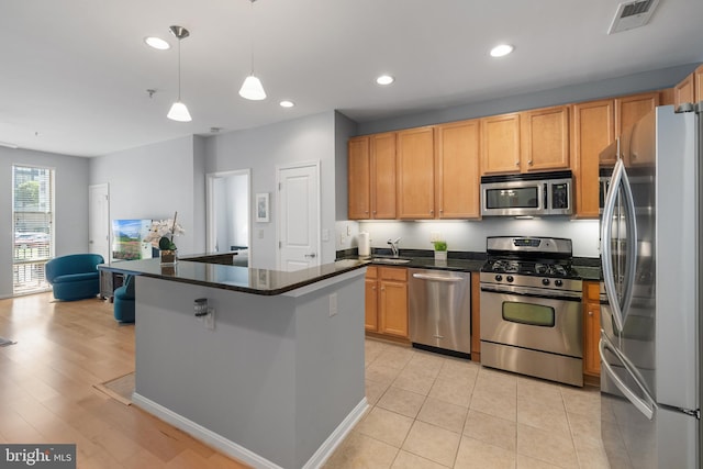 2665 Prosperity Ave Unit 109, Fairfax, VA 22031 - kitchen featuring appliances with stainless steel finishes, recessed lighting, a center island, decorative light fixtures, and light tile patterned flooring