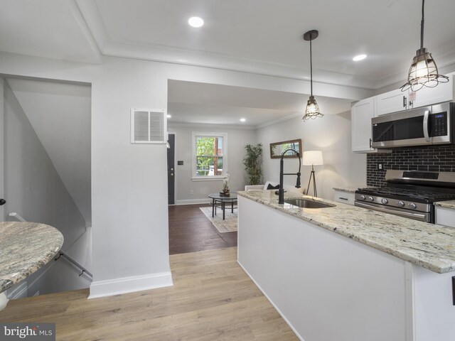 5623 Eads St NE, Washington, DC 20019 - kitchen with appliances with stainless steel finishes, a sink, crown molding, white cabinetry, and baseboards
