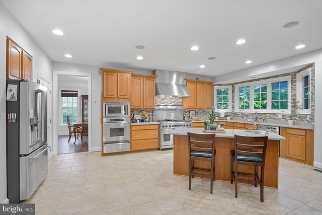 4904 Charmed Ct, Woodbridge, VA 22192 - kitchen featuring appliances with stainless steel finishes, wall chimney exhaust hood, light countertops, tasteful backsplash, and recessed lighting