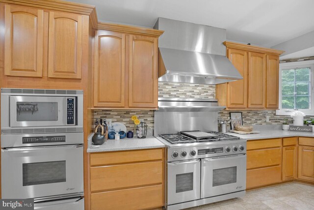 4904 Charmed Ct, Woodbridge, VA 22192 - kitchen featuring stainless steel appliances, wall chimney range hood, tasteful backsplash, and light countertops