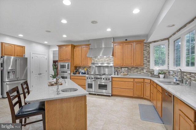 4904 Charmed Ct, Woodbridge, VA 22192 - kitchen featuring high end appliances, a sink, wall chimney exhaust hood, decorative backsplash, and recessed lighting