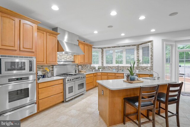 4904 Charmed Ct, Woodbridge, VA 22192 - kitchen with appliances with stainless steel finishes, wall chimney range hood, backsplash, a warming drawer, and recessed lighting