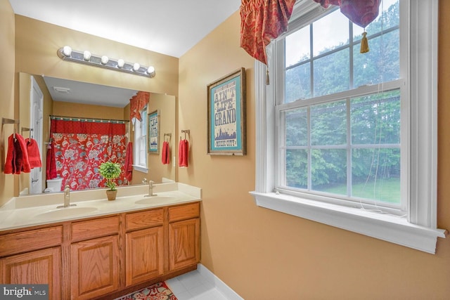4904 Charmed Ct, Woodbridge, VA 22192 - bathroom featuring double vanity, plenty of natural light, tile patterned floors, and baseboards