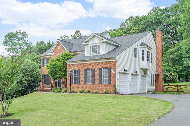 4904 Charmed Ct, Woodbridge, VA 22192 - view of front of house featuring asphalt driveway, brick siding, a chimney, a garage, and roof with shingles