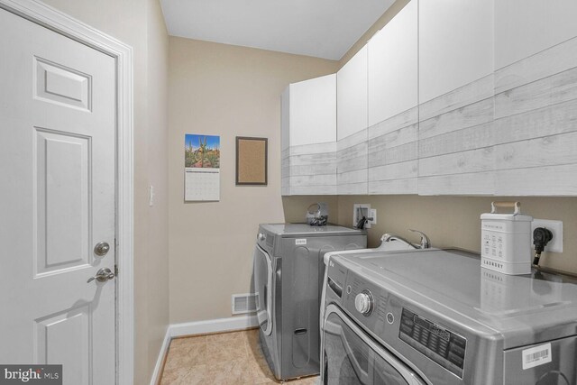 4904 Charmed Ct, Woodbridge, VA 22192 - laundry room featuring washer and clothes dryer, baseboards, and cabinet space