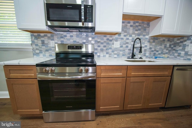 1407 Ruatan St, Hyattsville, MD 20783 - kitchen featuring stainless steel appliances, a sink, backsplash, and dark wood-style flooring