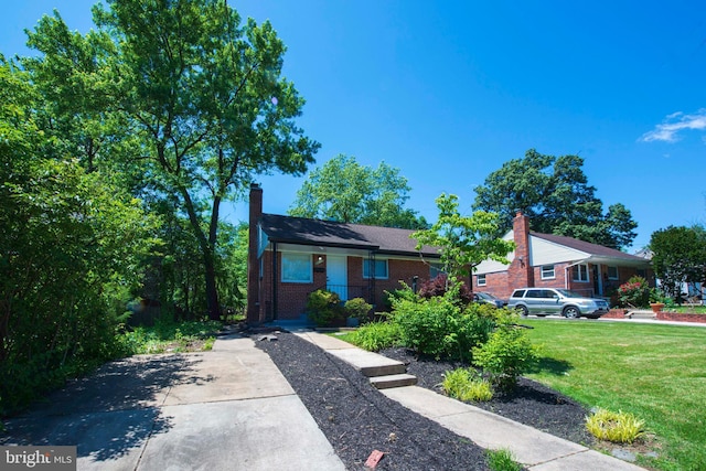 1407 Ruatan St, Hyattsville, MD 20783 - view of front of home with a front lawn, brick siding, and a chimney