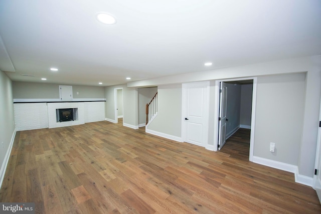 1407 Ruatan St, Hyattsville, MD 20783 - unfurnished living room featuring wood finished floors, recessed lighting, stairway, baseboards, and a fireplace