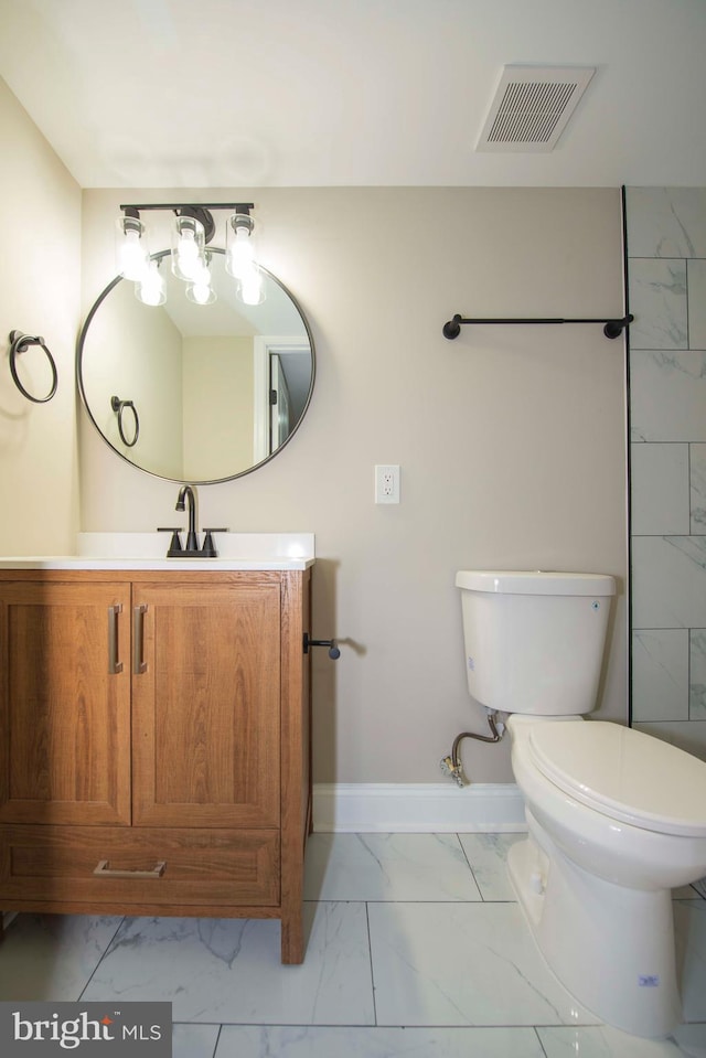 1407 Ruatan St, Hyattsville, MD 20783 - bathroom featuring marble look tiles, toilet, vanity, and baseboards