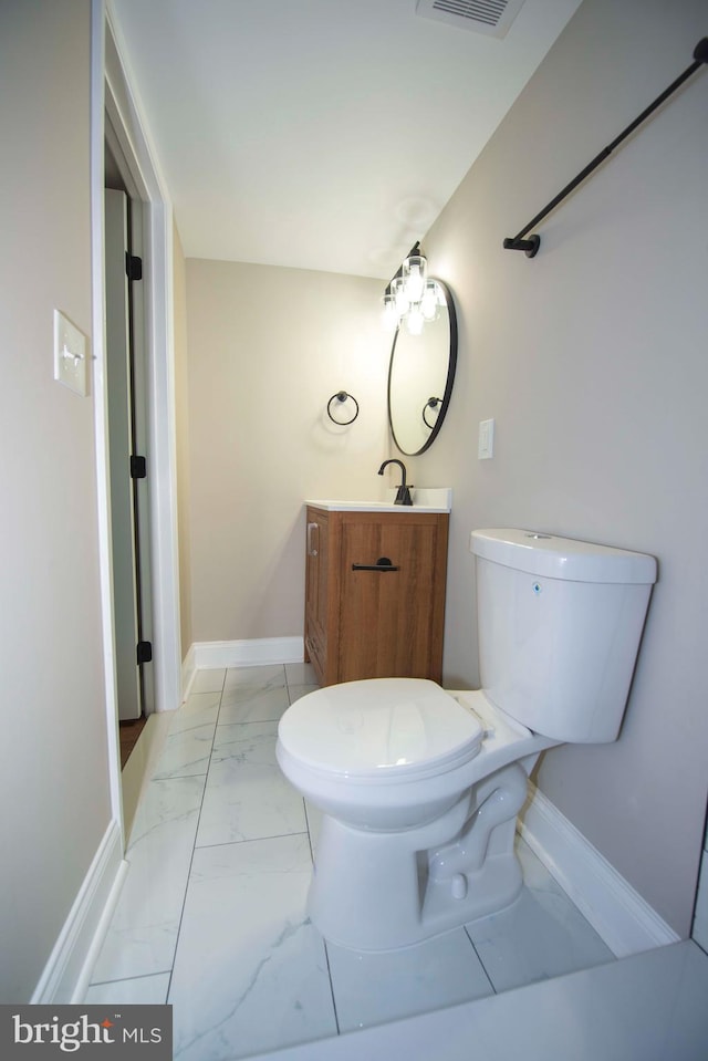 1407 Ruatan St, Hyattsville, MD 20783 - bathroom featuring marble finish floors, vanity, toilet, and baseboards