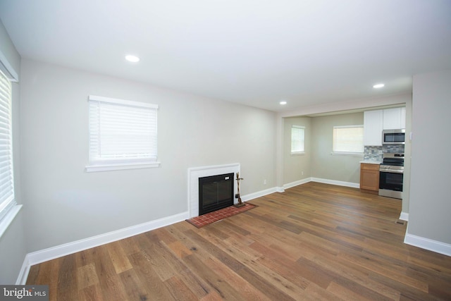 1407 Ruatan St, Hyattsville, MD 20783 - unfurnished living room with dark wood-style floors, a fireplace with flush hearth, baseboards, and recessed lighting