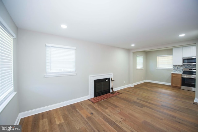 1407 Ruatan St, Hyattsville, MD 20783 - unfurnished living room featuring a glass covered fireplace, wood finished floors, baseboards, and recessed lighting