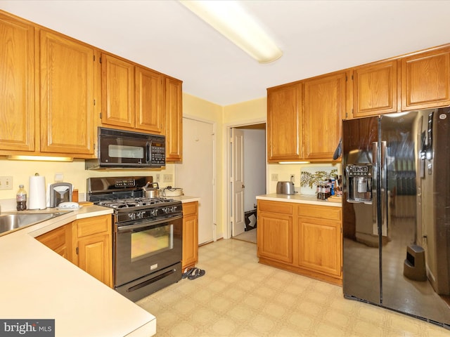 2409 Bear Den Rd, Frederick, MD 21701 - kitchen featuring black appliances, light countertops, light flooring, and brown cabinets