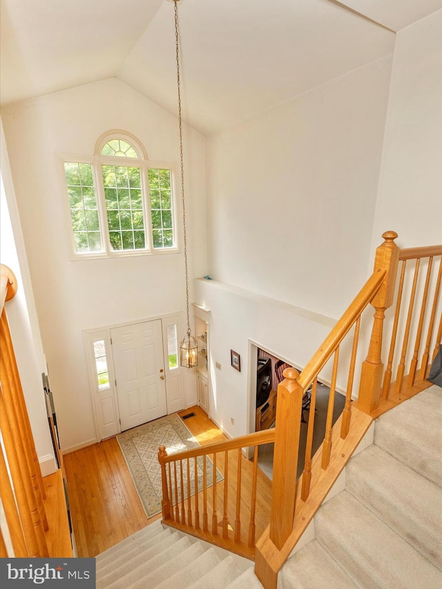 2409 Bear Den Rd, Frederick, MD 21701 - foyer with high vaulted ceiling, wood finished floors, stairs, and baseboards