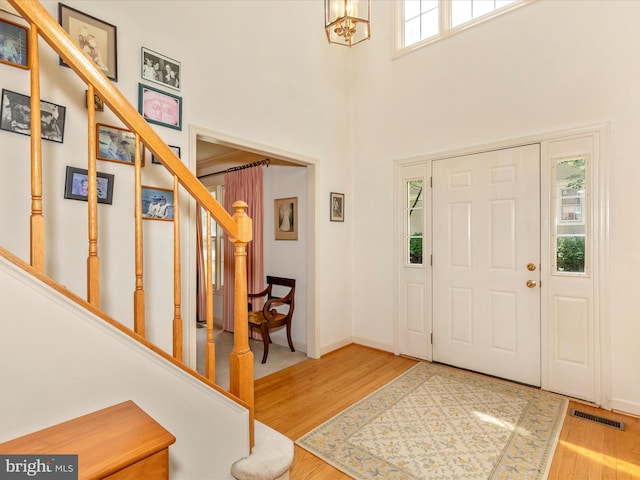 2409 Bear Den Rd, Frederick, MD 21701 - entrance foyer with stairs, wood finished floors, a high ceiling, a chandelier, and baseboards