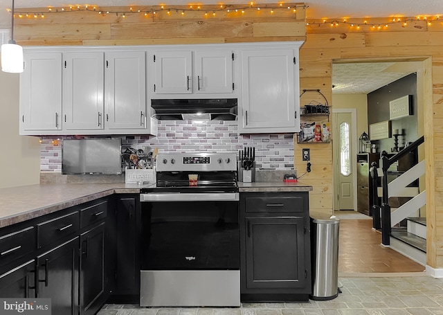 24950 Morgan Rd, Hollywood, MD 20636 - kitchen featuring under cabinet range hood, stainless steel range with electric cooktop, tasteful backsplash, white cabinets, and wooden walls