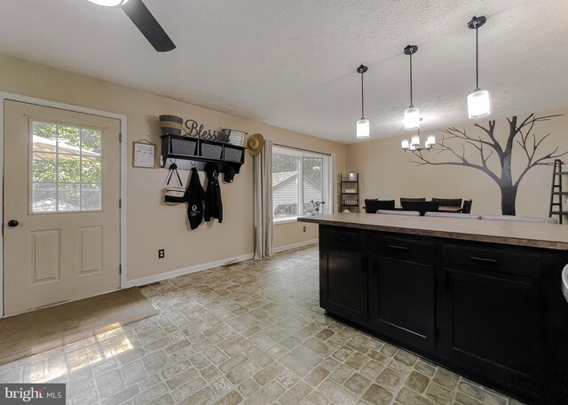 24950 Morgan Rd, Hollywood, MD 20636 - kitchen featuring dark cabinetry, baseboards, a textured ceiling, a chandelier, and light countertops