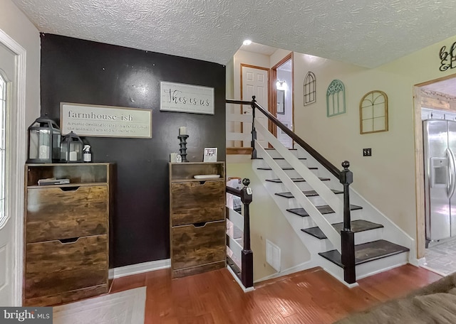 24950 Morgan Rd, Hollywood, MD 20636 - stairway featuring wood finished floors, a textured ceiling, and baseboards