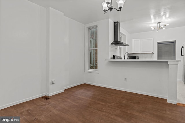 1504 N 57th St, Philadelphia, PA 19131 - kitchen featuring a chandelier, wall chimney exhaust hood, dark wood-type flooring, baseboards, and white cabinets