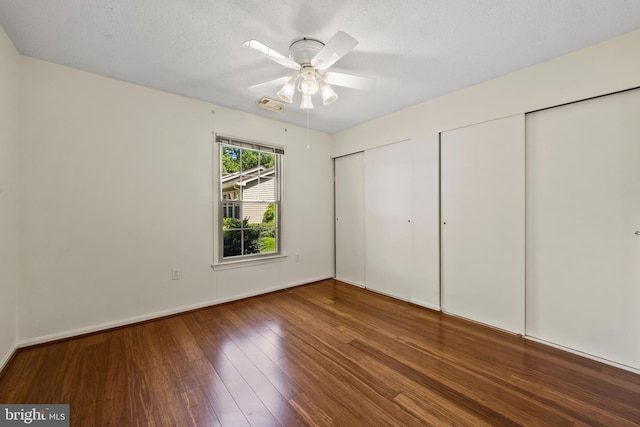2516 N Haven Cv, Annapolis, MD 21401 - unfurnished bedroom with multiple closets, wood finished floors, a ceiling fan, and a textured ceiling