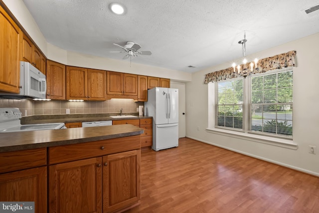 2516 N Haven Cv, Annapolis, MD 21401 - kitchen with white appliances, a sink, brown cabinets, dark countertops, and a textured ceiling