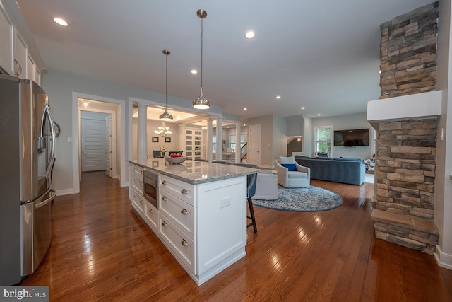 11 Ridings Way, West Chester, PA 19382 - kitchen with appliances with stainless steel finishes, white cabinets, a breakfast bar area, light stone countertops, and recessed lighting