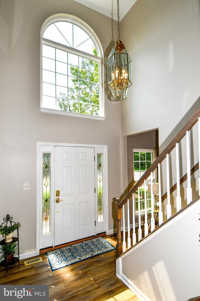 9111 Dartford Pl, Bristow, VA 20136 - entrance foyer with a chandelier, a towering ceiling, wood finished floors, and crown molding