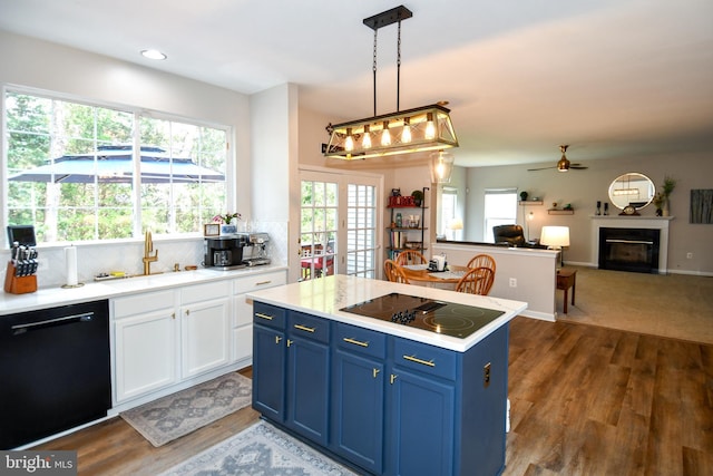 9111 Dartford Pl, Bristow, VA 20136 - kitchen with black appliances, blue cabinetry, a glass covered fireplace, light countertops, and dark wood-style floors