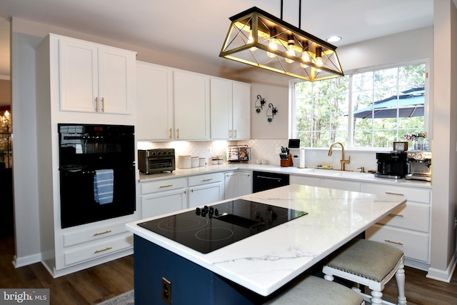 9111 Dartford Pl, Bristow, VA 20136 - kitchen featuring black appliances, a kitchen island, backsplash, dark wood finished floors, and light stone counters