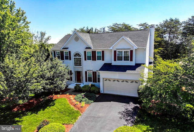 9111 Dartford Pl, Bristow, VA 20136 - view of front facade featuring a garage, driveway, a chimney, and roof with shingles