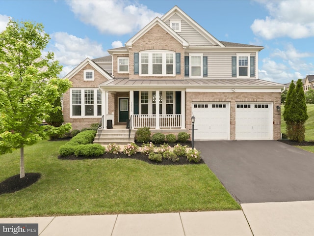 42350 Stonemont Cir, Ashburn, VA 20148 - view of front of home with brick siding, a standing seam roof, covered porch, driveway, and an attached garage