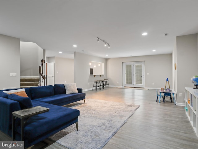 42350 Stonemont Cir, Ashburn, VA 20148 - living room with light wood-style floors, stairs, baseboards, recessed lighting, and rail lighting