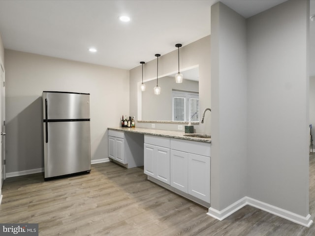 42350 Stonemont Cir, Ashburn, VA 20148 - kitchen featuring freestanding refrigerator, light wood-style flooring, a sink, white cabinets, and baseboards