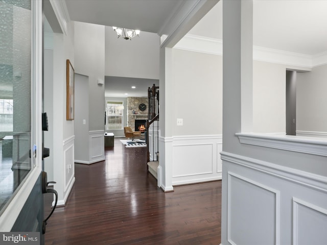 42350 Stonemont Cir, Ashburn, VA 20148 - entryway with dark wood-style flooring, ornamental molding, a chandelier, a wainscoted wall, and a stone fireplace