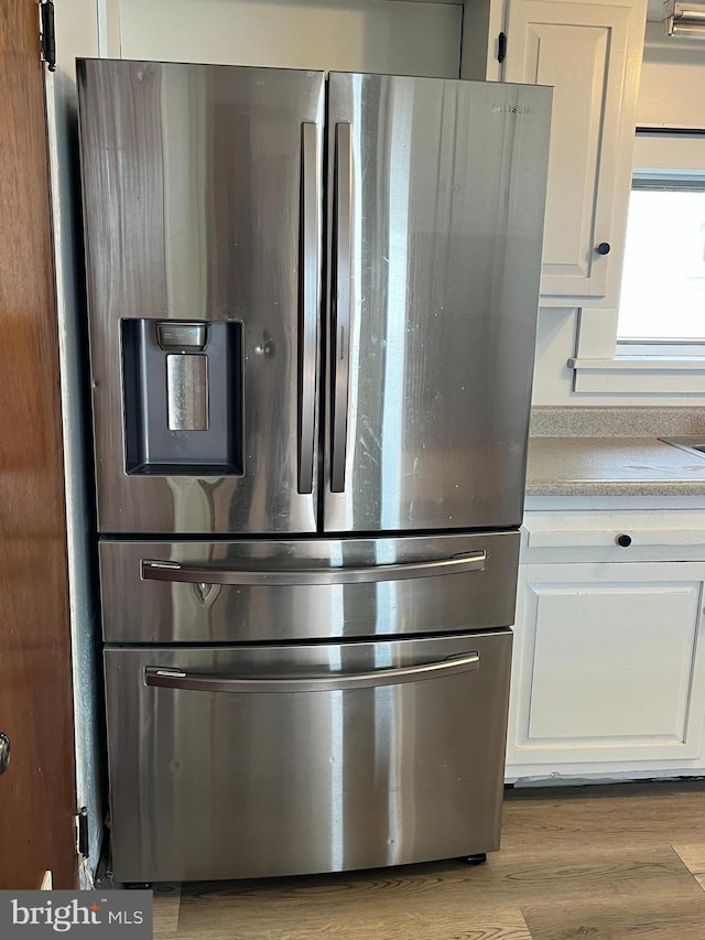 517 S Wayne St, Lewistown, PA 17044 - kitchen view of stainless steel fridge, white cabinetry, light countertops, and light wood-style floors