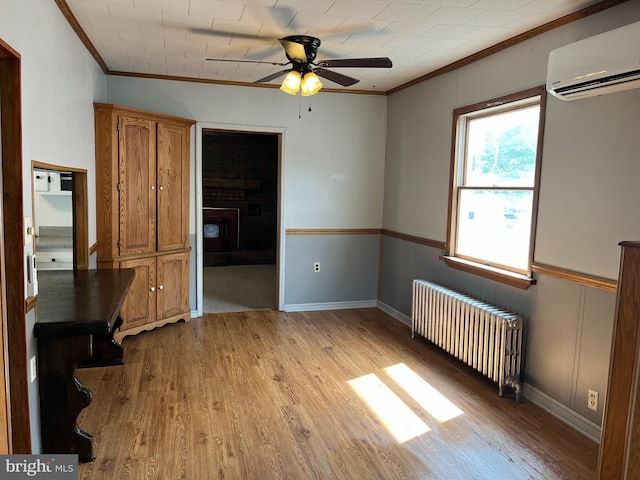 517 S Wayne St, Lewistown, PA 17044 - spare room with radiator, a wall mounted AC, ornamental molding, light wood finished floors, and a ceiling fan