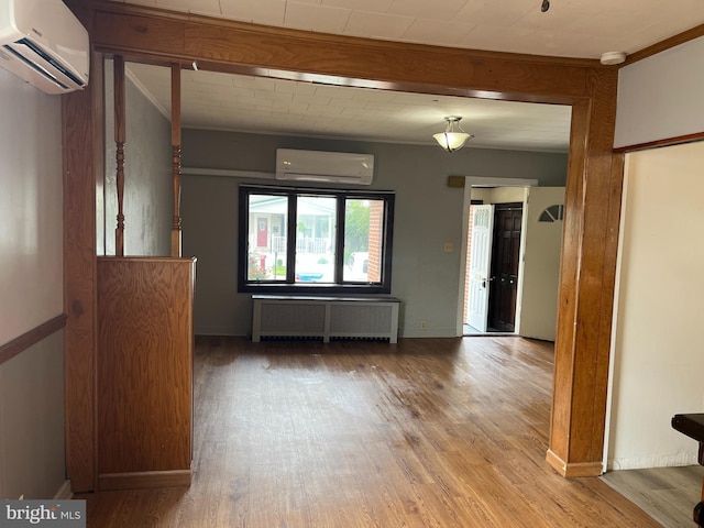 517 S Wayne St, Lewistown, PA 17044 - empty room with radiator heating unit, a wall unit AC, wood finished floors, crown molding, and baseboards