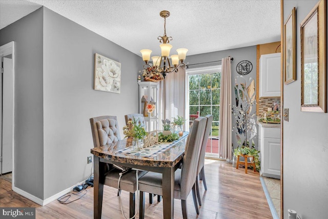 859 Columbia Ave, Newfield, NJ 08344 - dining space with a chandelier, light wood finished floors, a textured ceiling, and baseboards