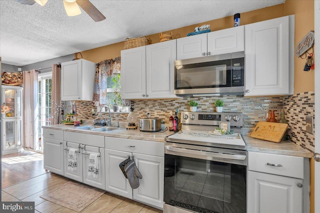 859 Columbia Ave, Newfield, NJ 08344 - kitchen featuring appliances with stainless steel finishes, a sink, a textured ceiling, light countertops, and white cabinetry