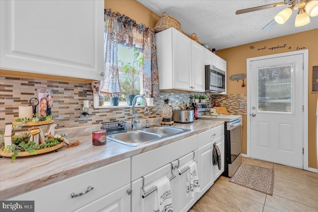859 Columbia Ave, Newfield, NJ 08344 - kitchen with stainless steel appliances, a sink, light countertops, white cabinets, and decorative backsplash